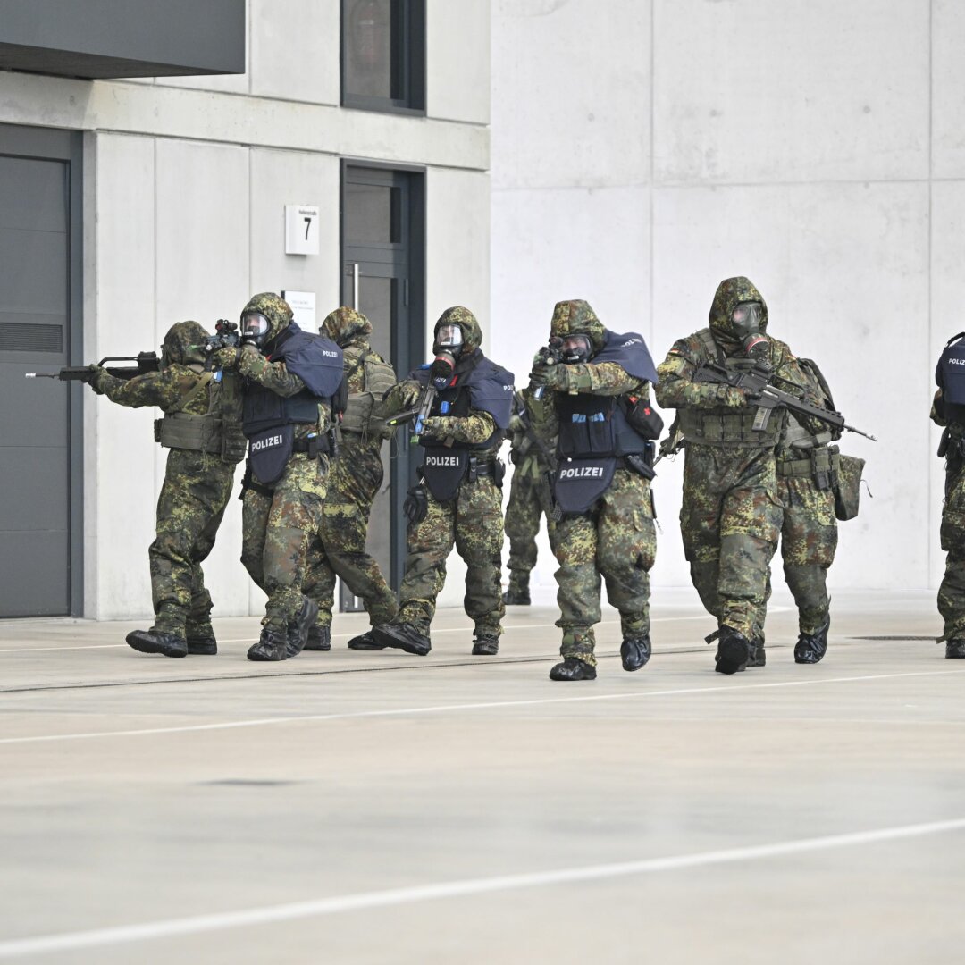 Auf dem Bild sind mehrere Polizeibeamte und Bundeswehrsoldaten in ihren jeweiligen Tarnuniformen zu sehen, die im Rahmen der MainTEX 2024 - Übung im Einsatz sind.